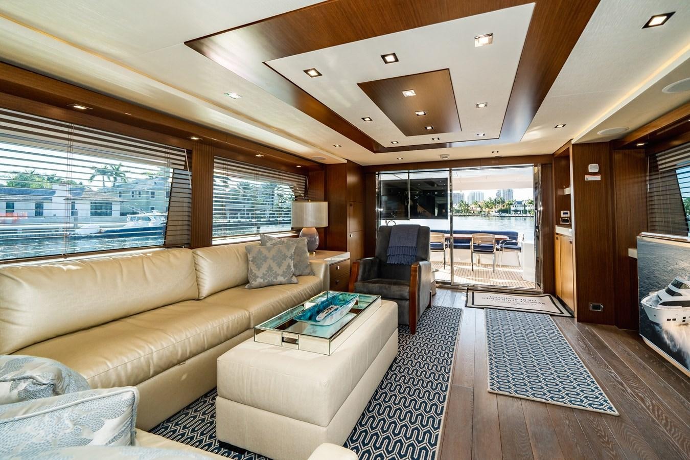 a living room with a couch and a table aboard 2017 HATTERAS M75 K SEA Yacht for Sale