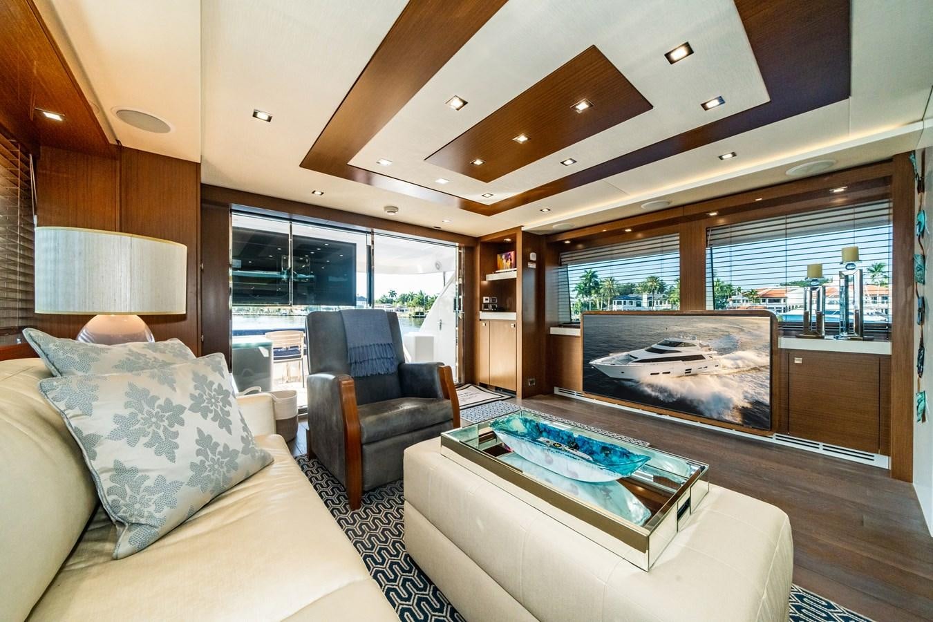 a living room with a fireplace aboard 2017 HATTERAS M75 K SEA Yacht for Sale