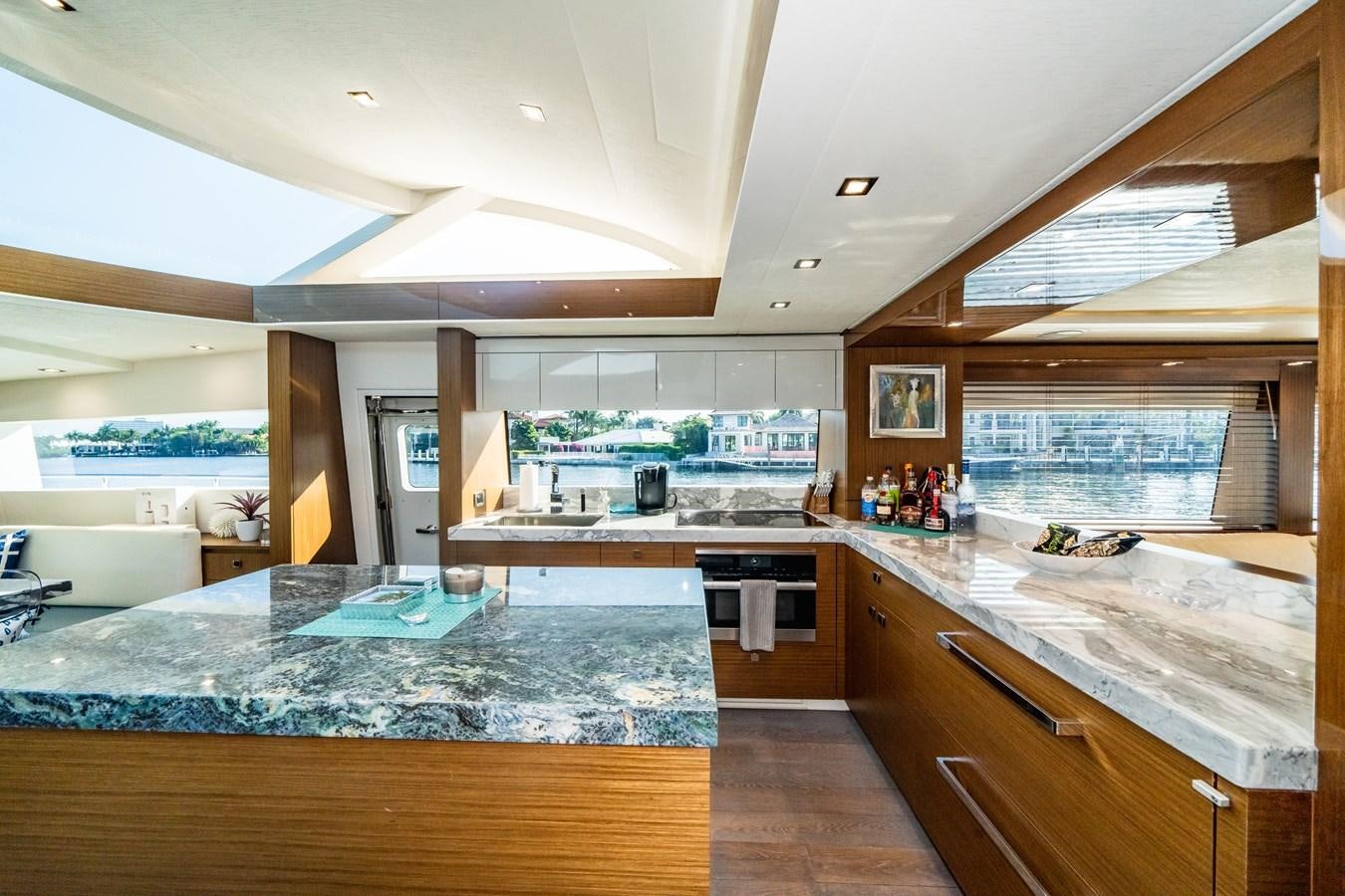 a large kitchen with a large countertop and a large window aboard 2017 HATTERAS M75 K SEA Yacht for Sale