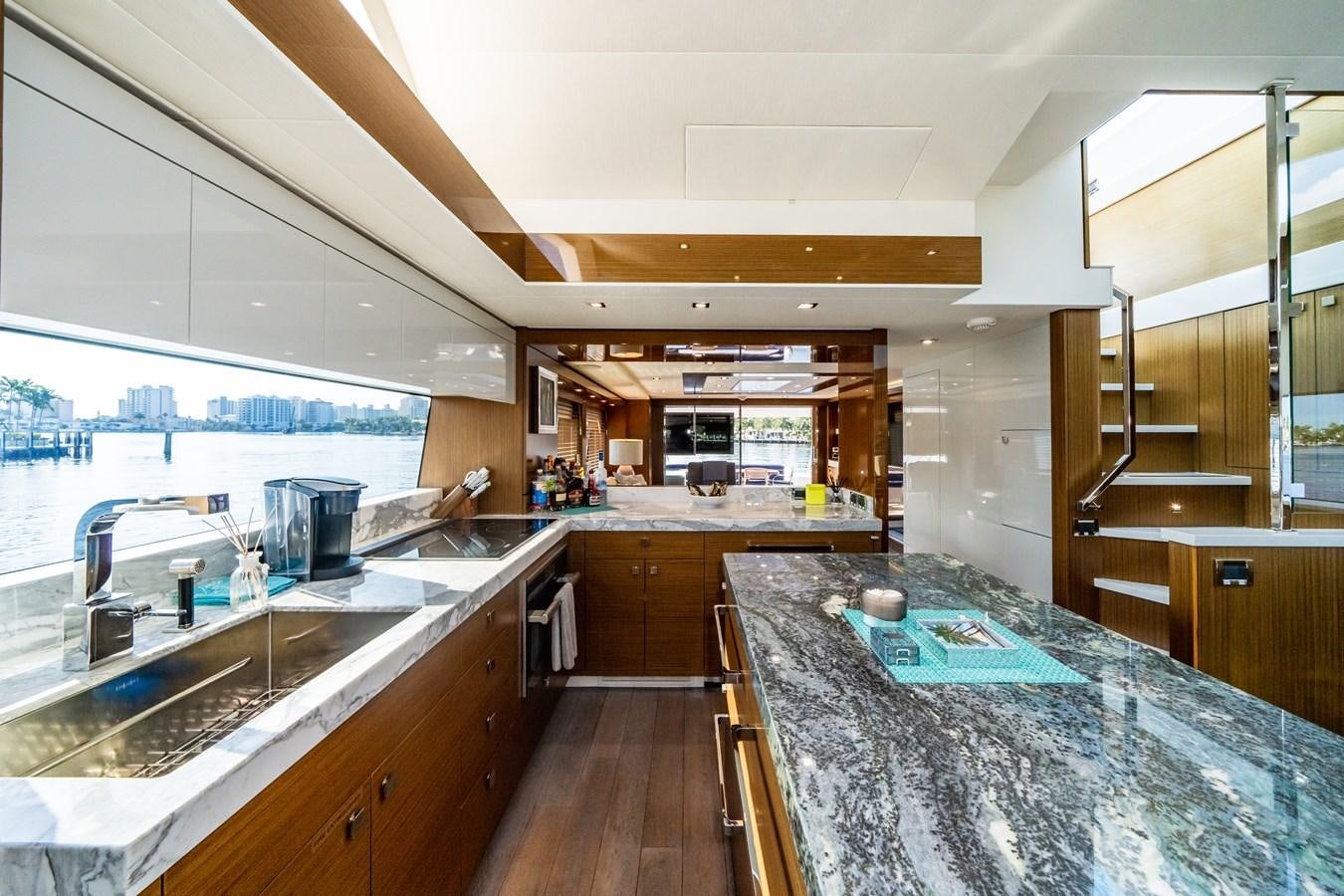 a large kitchen with a marble counter top aboard 2017 HATTERAS M75 K SEA Yacht for Sale