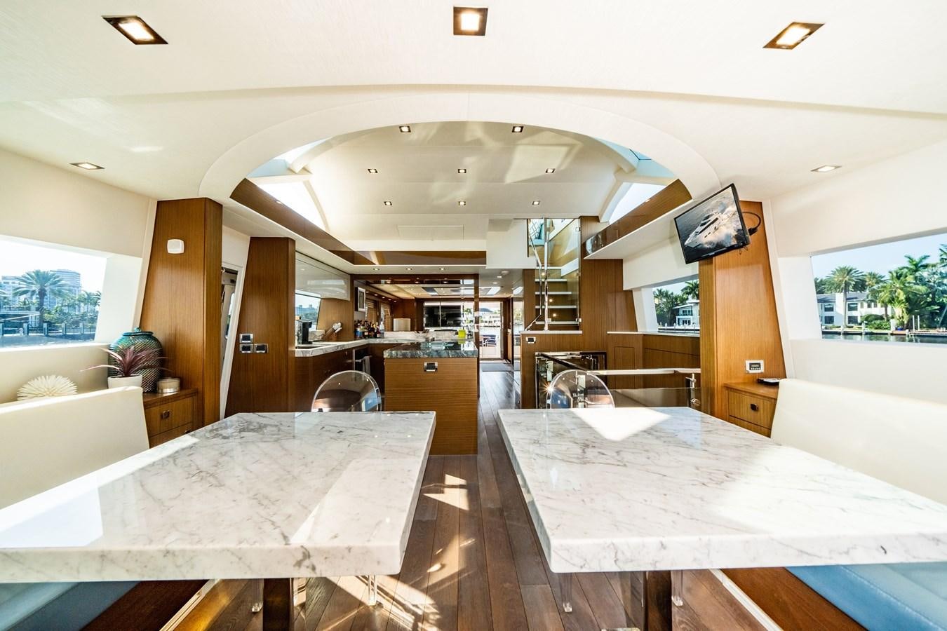 a room with tables and chairs aboard 2017 HATTERAS M75 K SEA Yacht for Sale