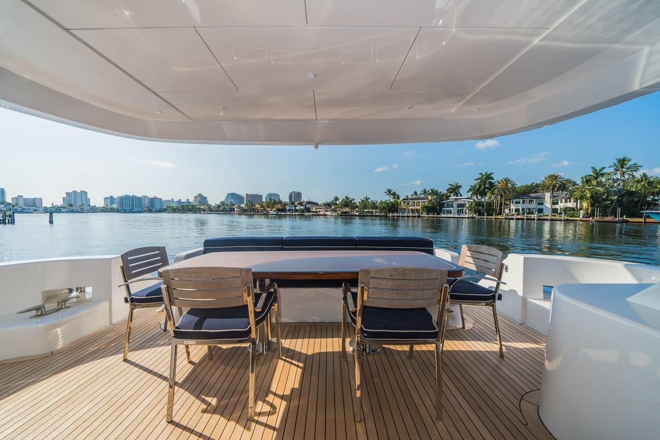 a table and chairs on a deck aboard 2017 HATTERAS M75 K SEA Yacht for Sale