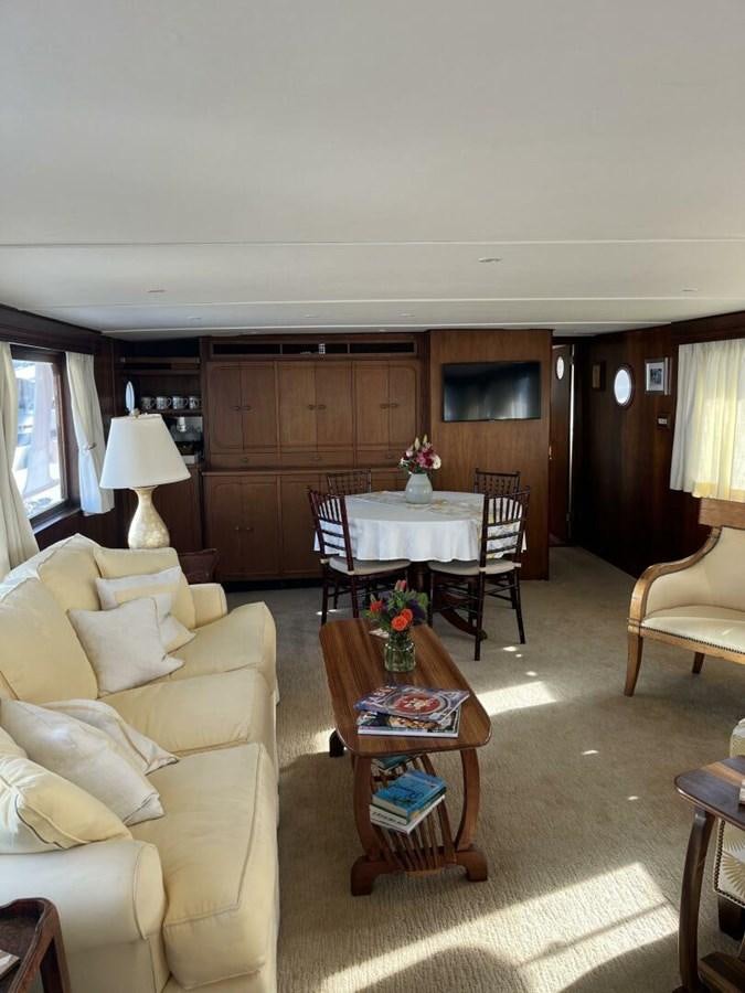 a living room with a table and chairs aboard DOVETAIL Yacht for Sale