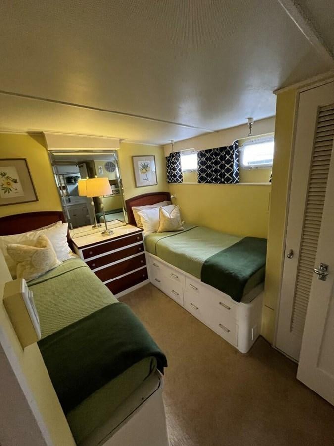 a bedroom with a bed and a chair aboard DOVETAIL Yacht for Sale