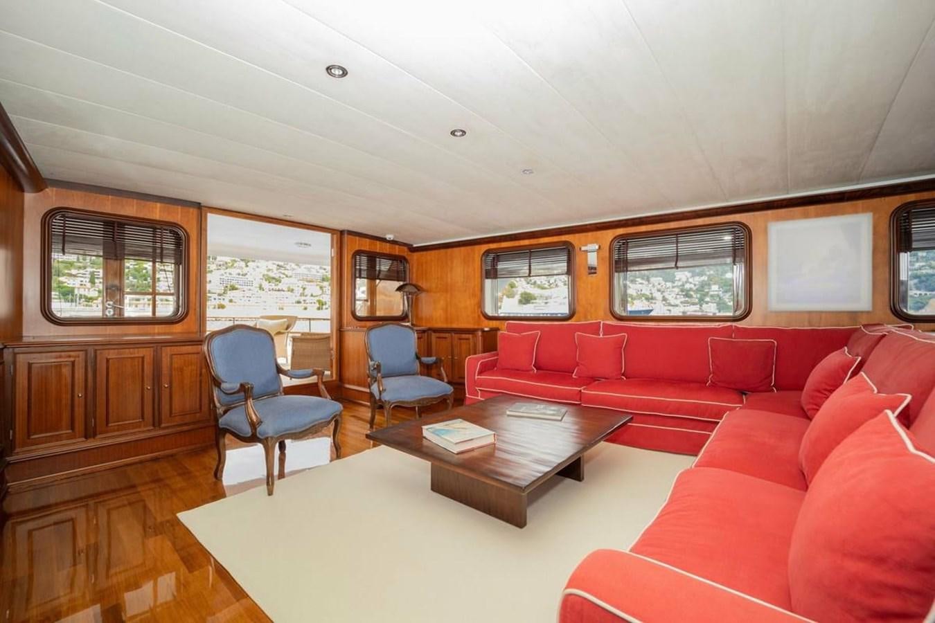a living room with red couches aboard CLASSIC 40M BENETTI Yacht for Sale