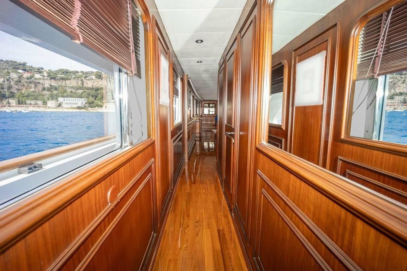 a wood deck with a wood railing and a window with a view of a city aboard CLASSIC 40M BENETTI Yacht for Sale