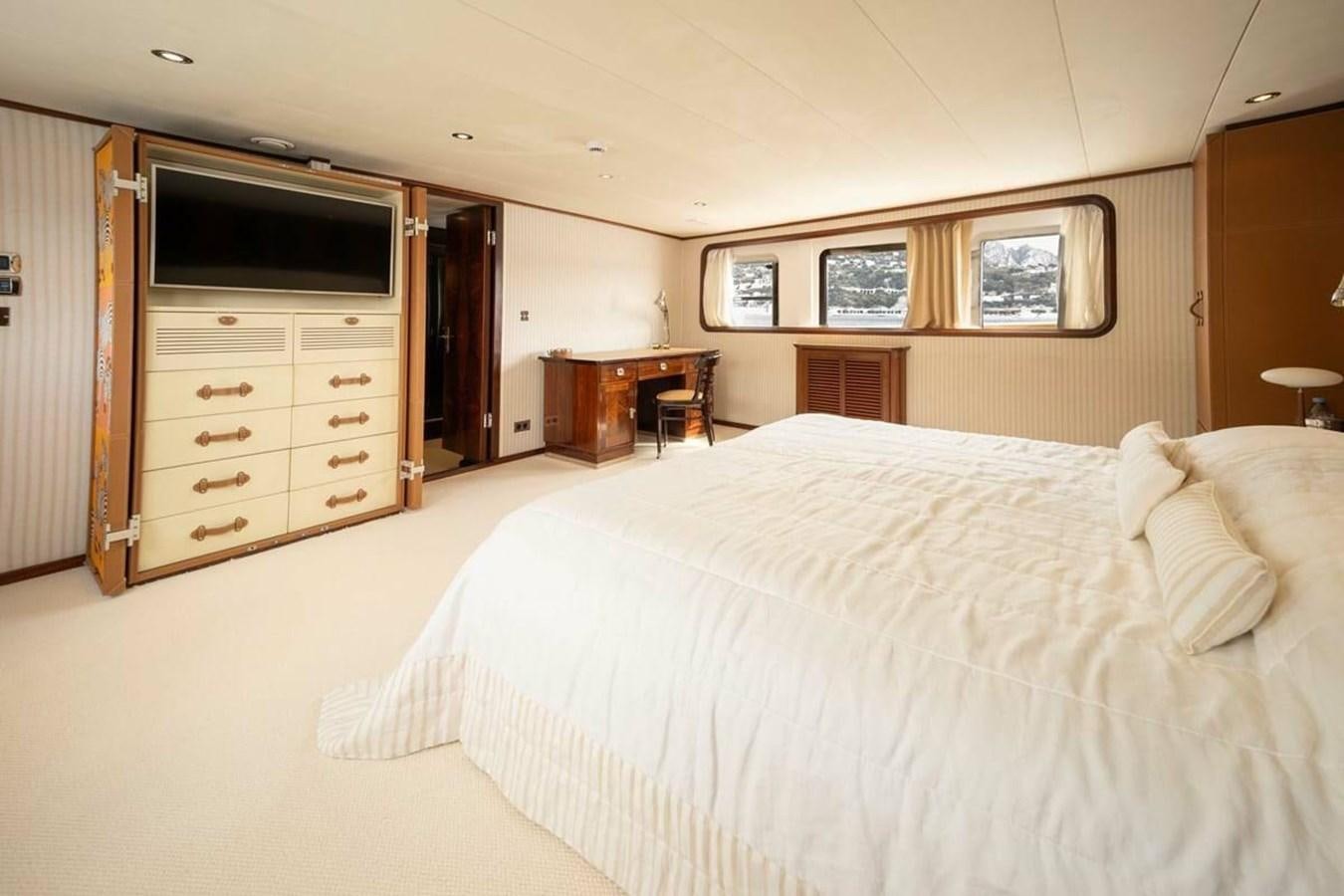 a bedroom with a bed and a television aboard CLASSIC 40M BENETTI Yacht for Sale