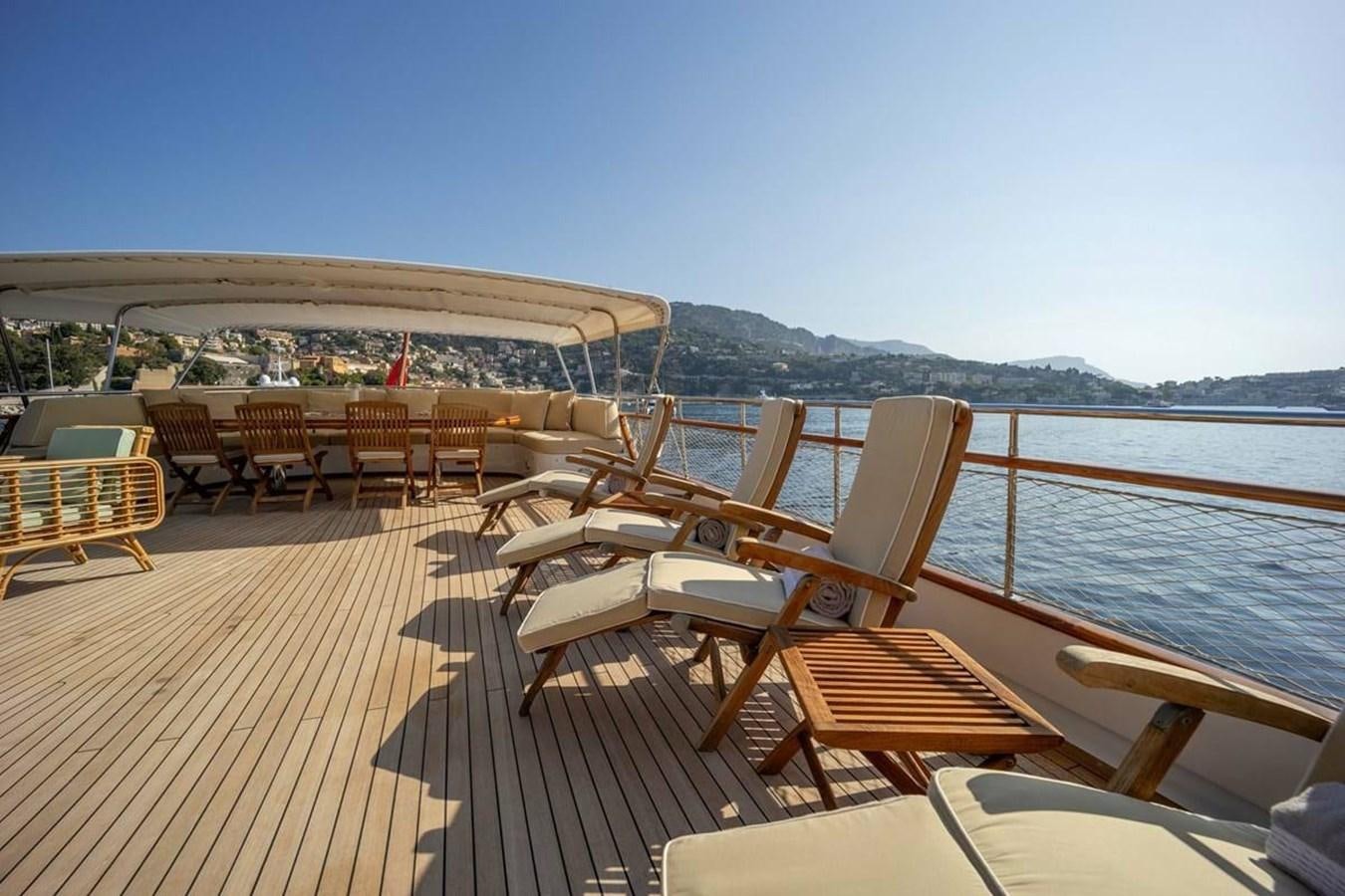 a deck with chairs and tables on it aboard CLASSIC 40M BENETTI Yacht for Sale