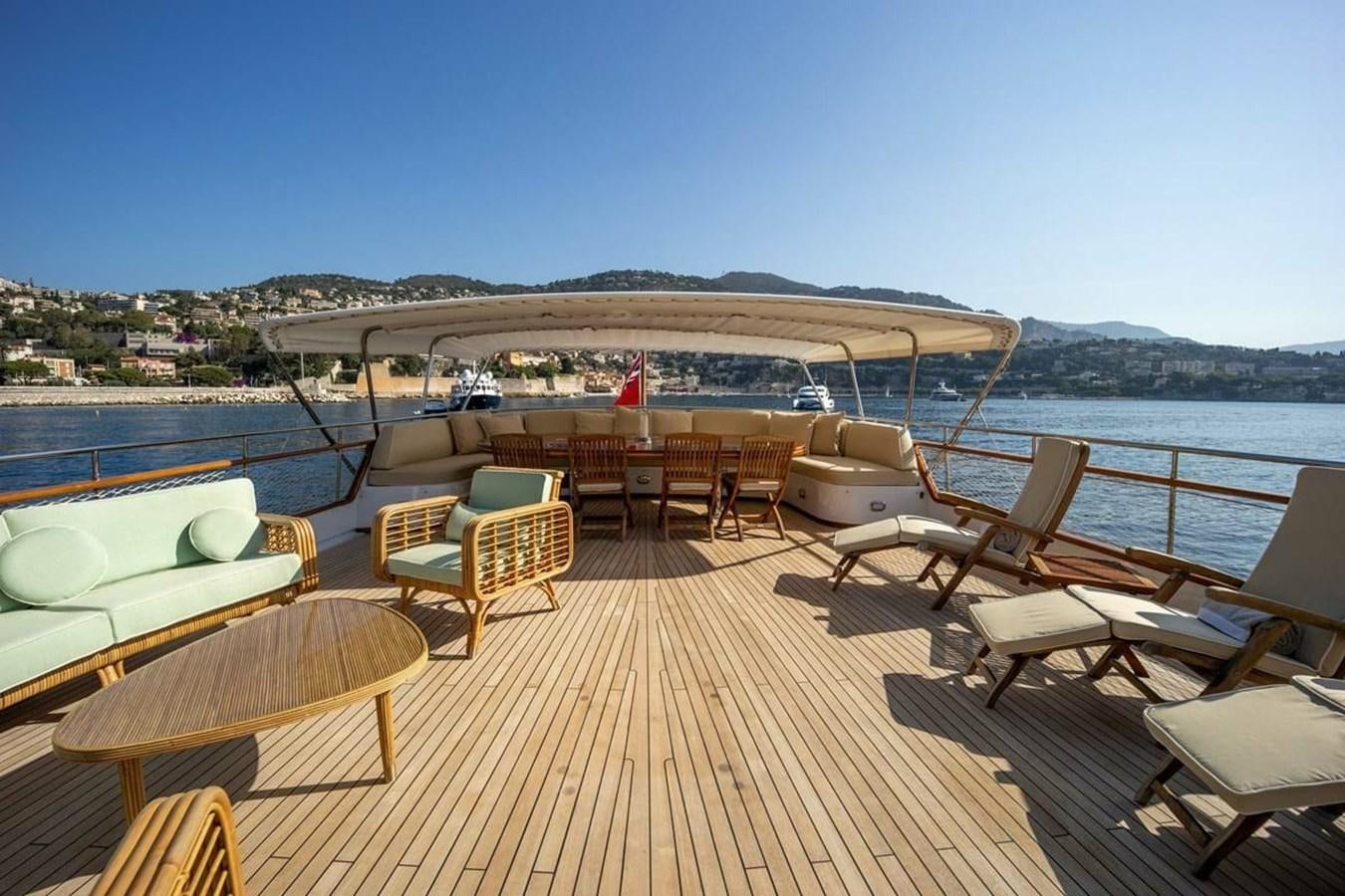 a deck with chairs and tables on it by the water aboard CLASSIC 40M BENETTI Yacht for Sale