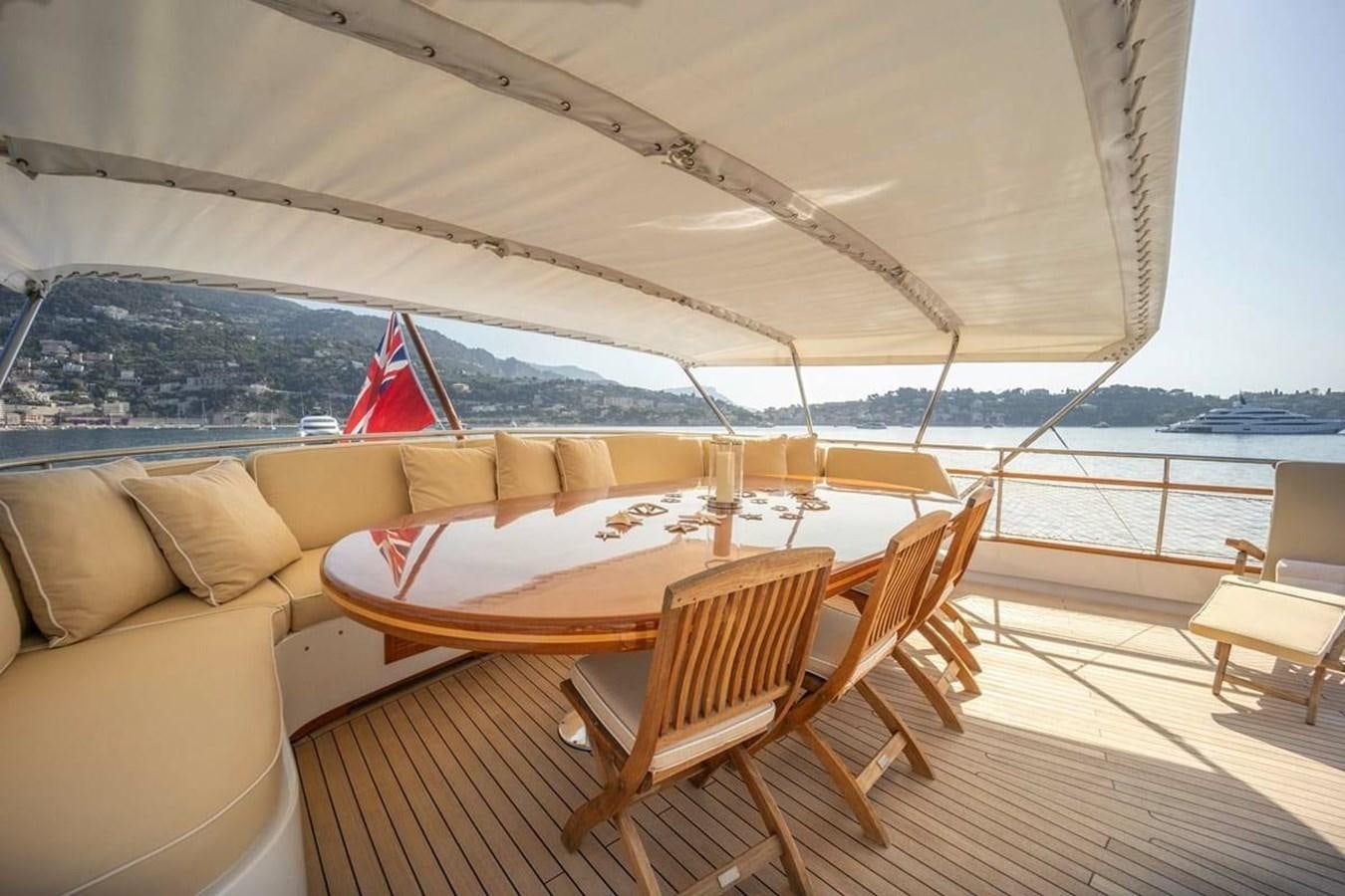 a table and chairs on a deck aboard CLASSIC 40M BENETTI Yacht for Sale