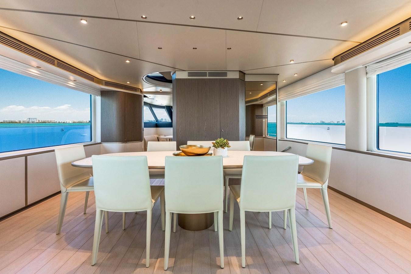 a large kitchen with white chairs aboard EQUITES Yacht for Sale