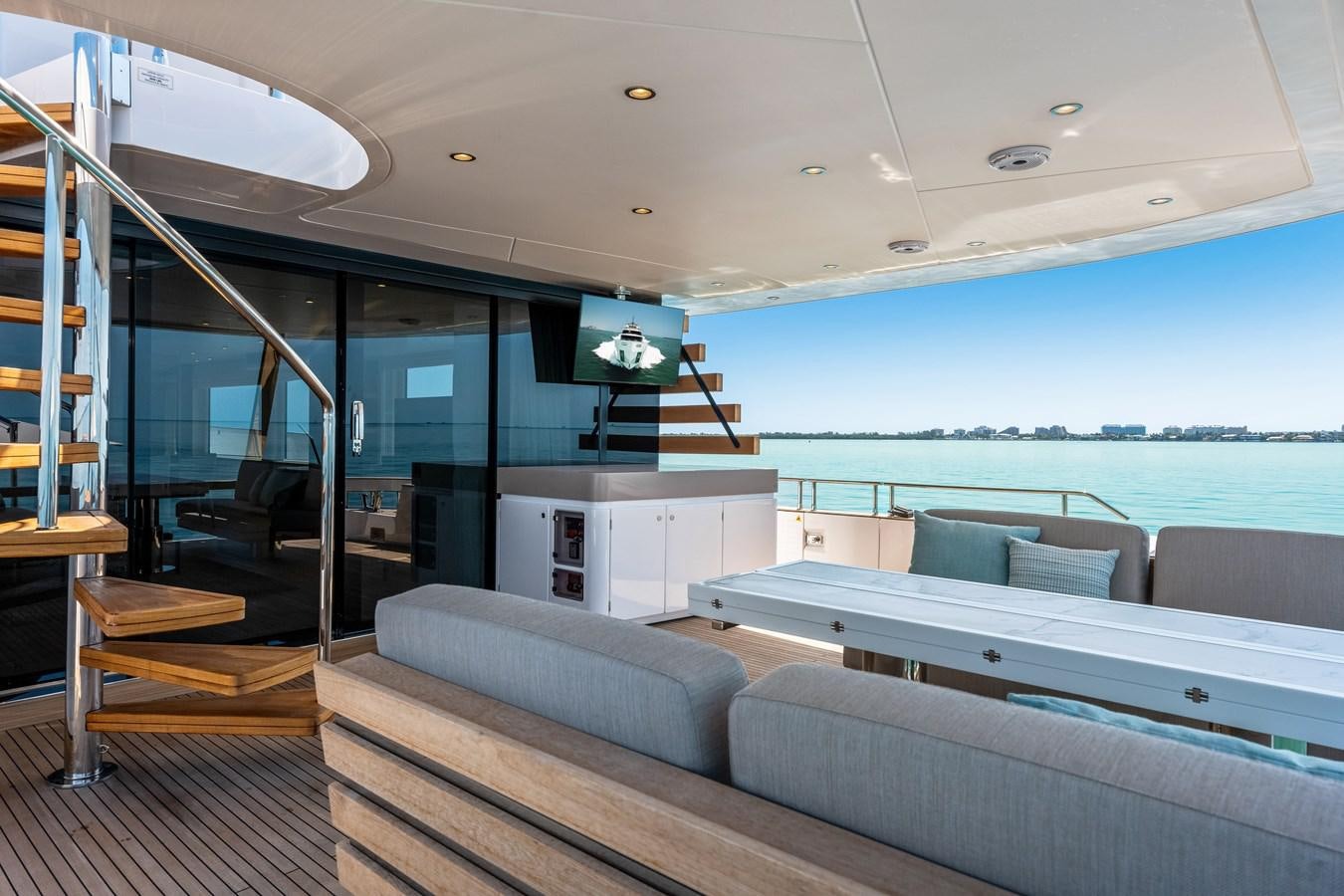 a living room with a large glass window and a view of the ocean aboard EQUITES Yacht for Sale