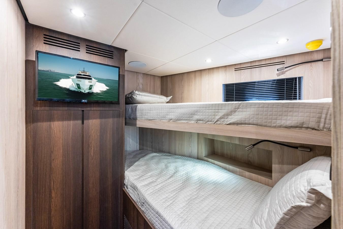 a television on a wall in a room with beds aboard EQUITES Yacht for Sale