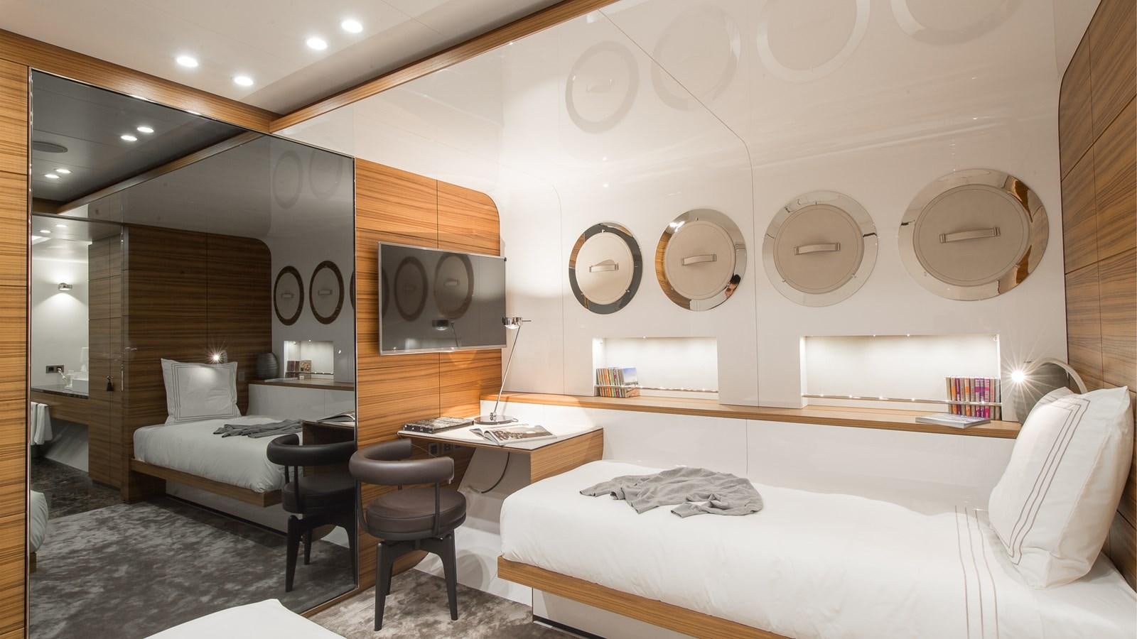 a room with a bed and a desk aboard SILVER EDGE Yacht for Sale