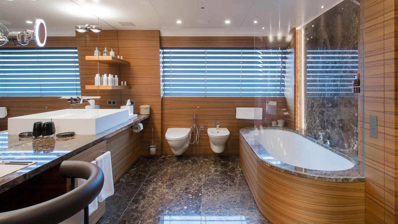 a bathroom with a tub sink and toilet aboard SILVER EDGE Yacht for Sale