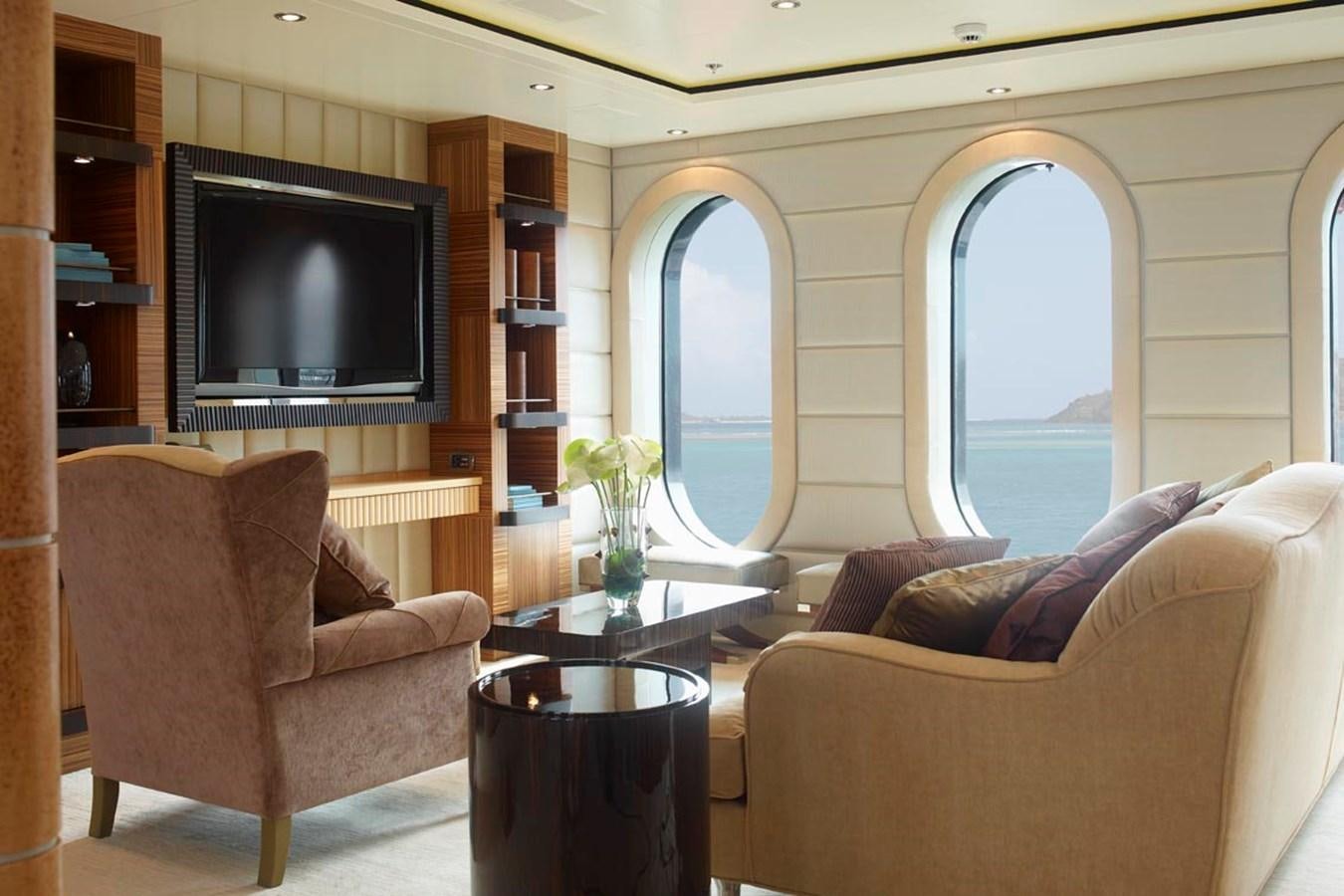 a living room with a tv and a table aboard PREDATOR Yacht for Sale