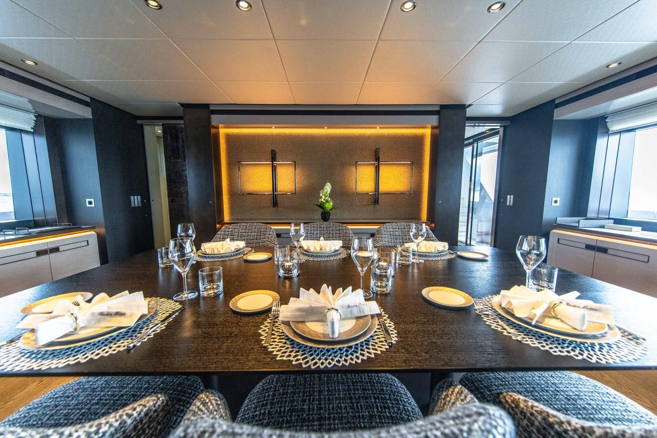a large dining table with plates and glasses on it aboard VAN TOM Yacht for Sale