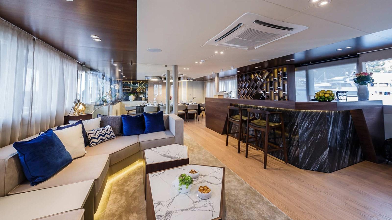 a living room with a large table and couches aboard CLASE AZUL Yacht for Sale