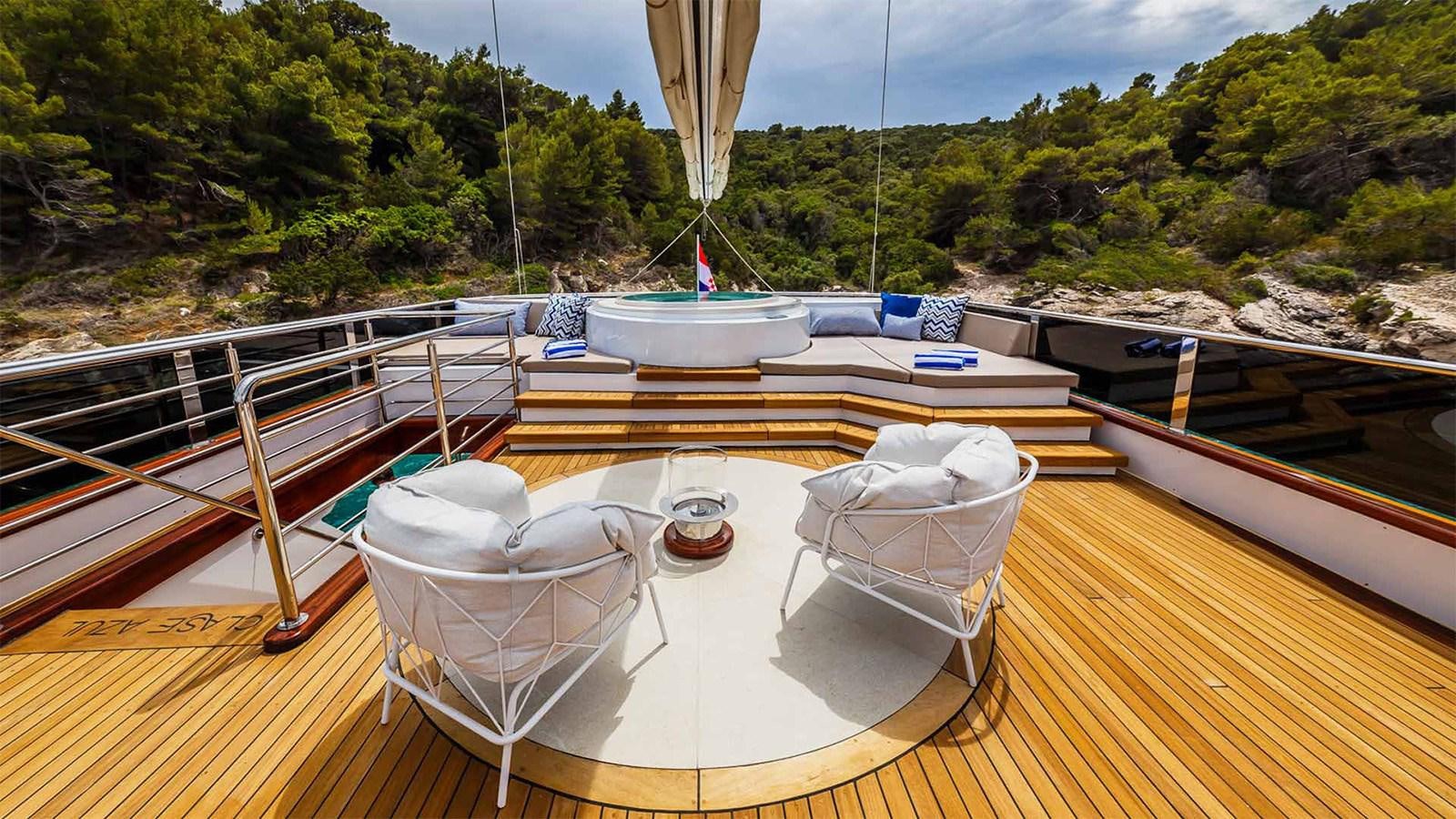 a table with chairs on it next to a boat on a river aboard CLASE AZUL Yacht for Sale