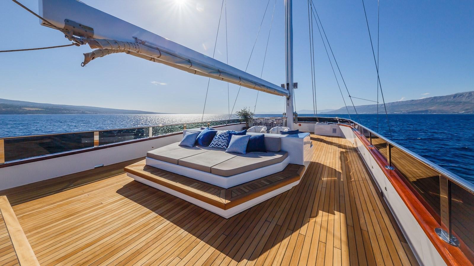 a deck with a view of the ocean and mountains aboard CLASE AZUL Yacht for Sale
