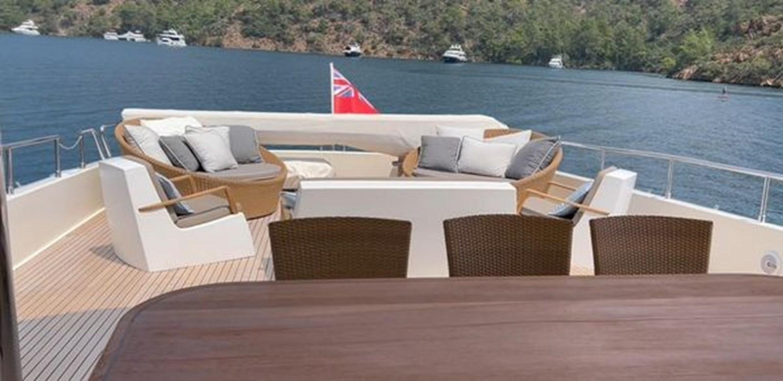 a deck with chairs and a flag on it aboard STELLA MARIS Yacht for Sale