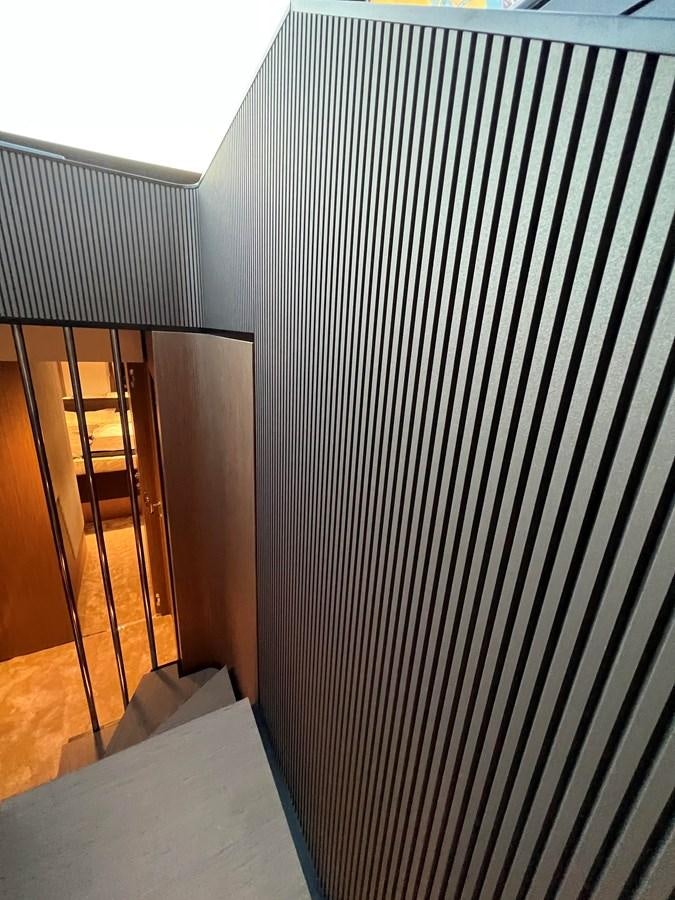 a room with a black and white striped wall and wood floor aboard AISULU Yacht for Sale