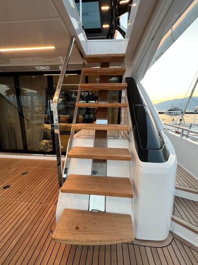 a wooden chair on a deck aboard AISULU Yacht for Sale