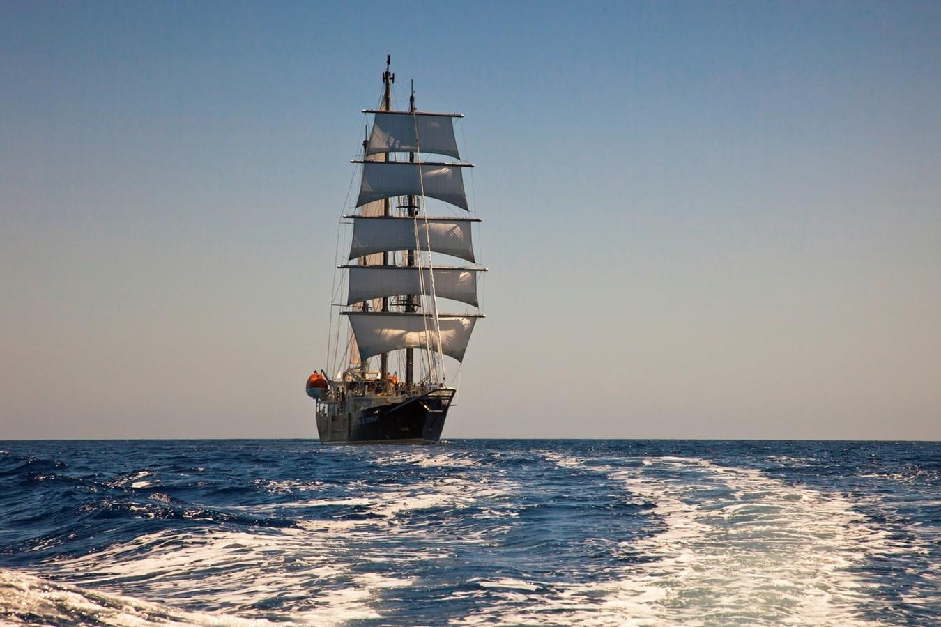 a tall ship in the water aboard RUNNING ON WAVES Yacht for Sale