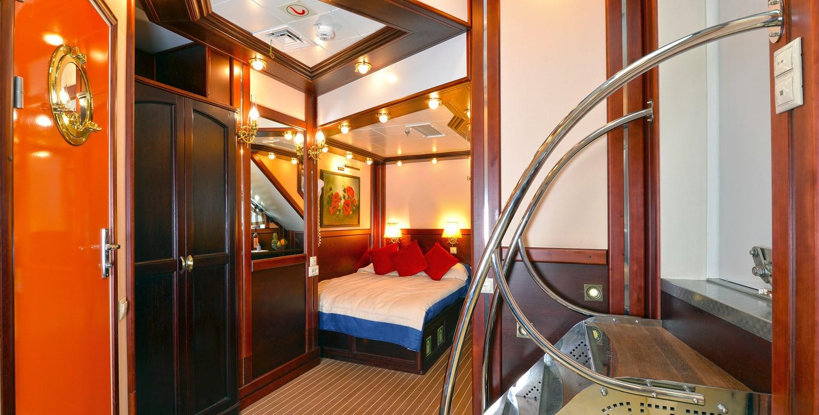 a bedroom with a bed and a mirror aboard RUNNING ON WAVES Yacht for Sale