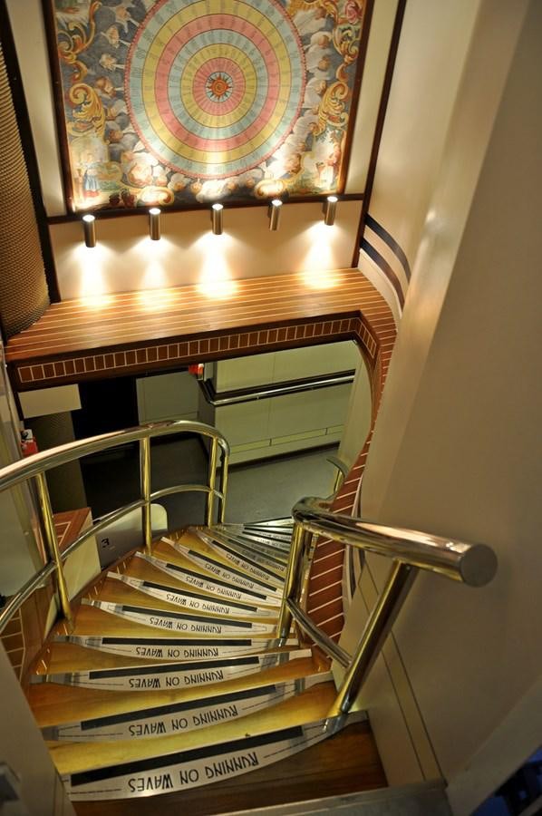 a staircase with a chandelier aboard RUNNING ON WAVES Yacht for Sale