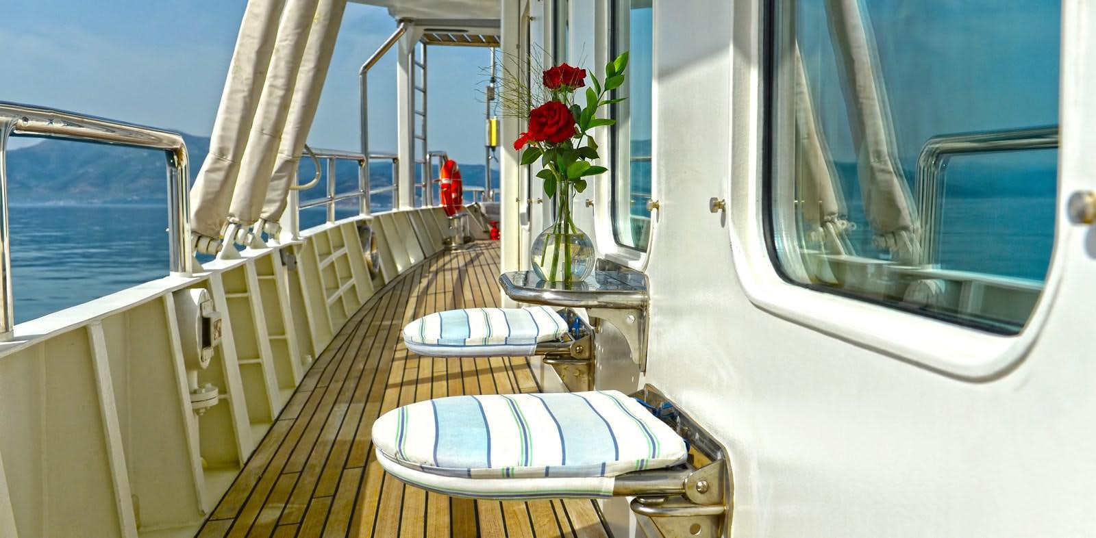 a balcony with a table and chairs aboard RUNNING ON WAVES Yacht for Sale