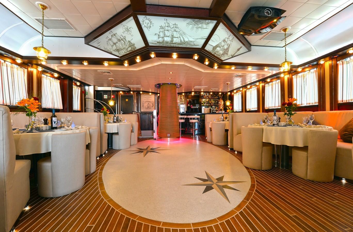 a large room with tables and chairs aboard RUNNING ON WAVES Yacht for Sale