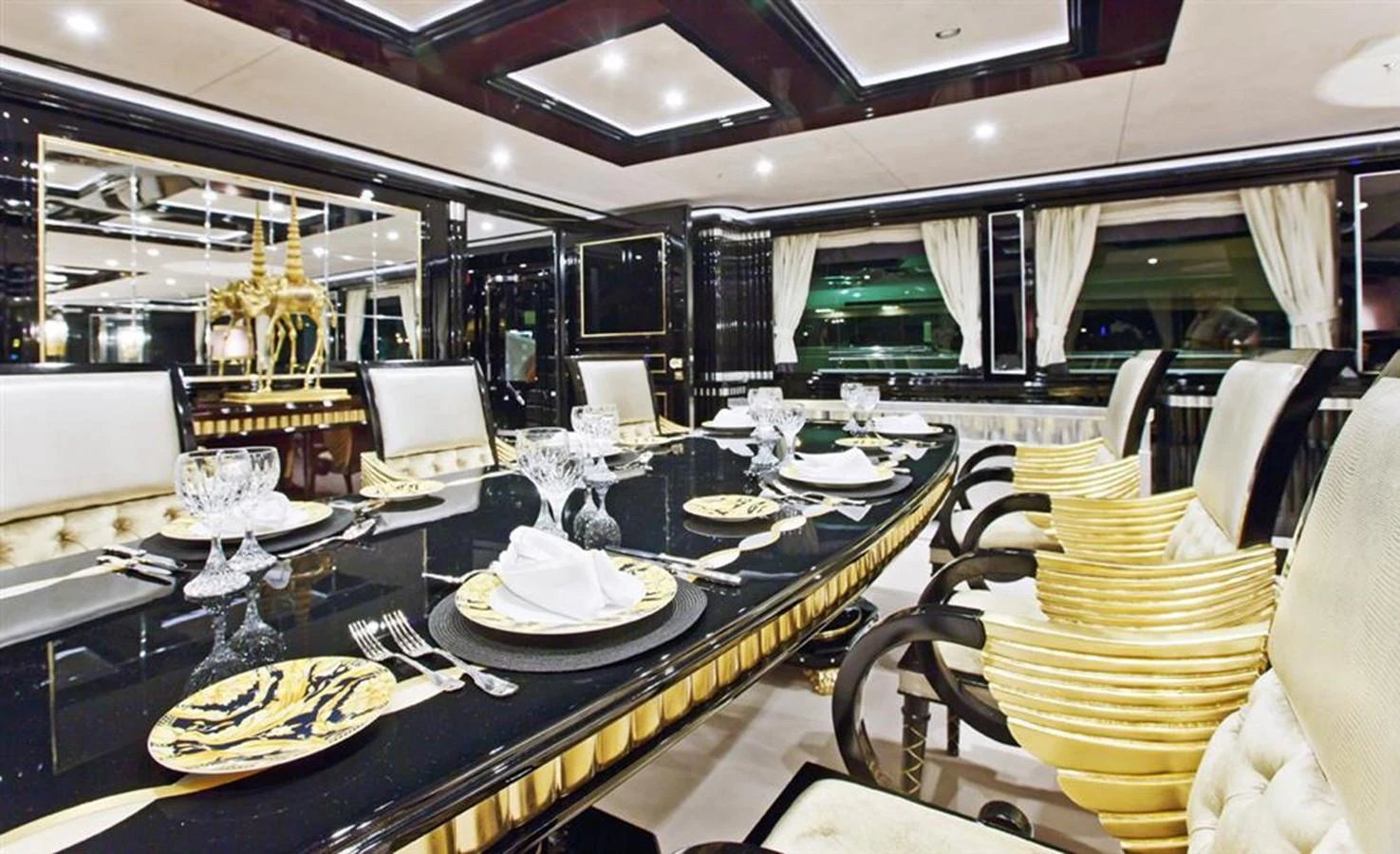 a large dining room with a large table set with plates and chairs aboard ALEXANDER AGAIN Yacht for Sale