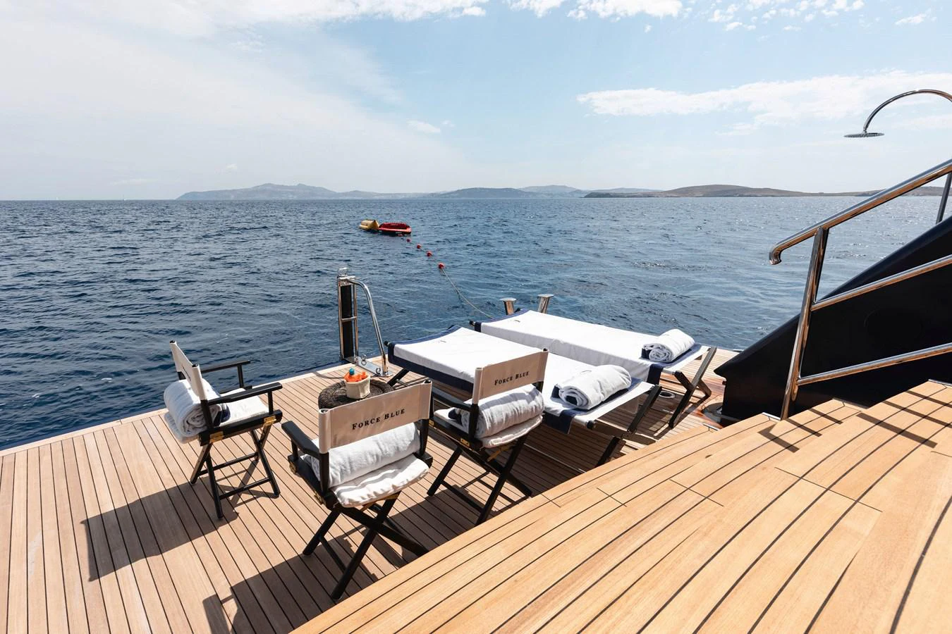 a deck with chairs and tables on it by the water aboard FORCE BLUE Yacht for Sale
