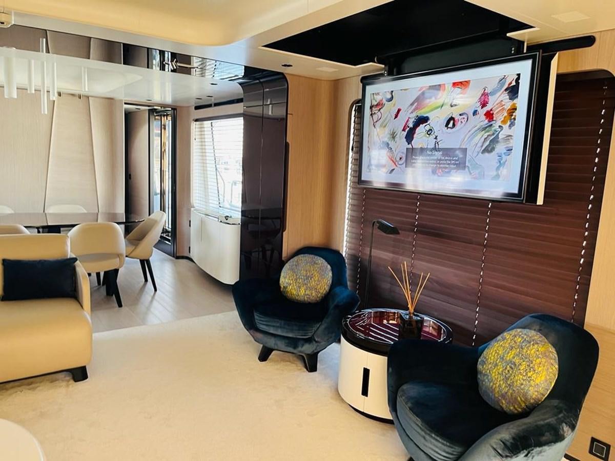 a living room with a tv and chairs aboard LULWA Yacht for Sale