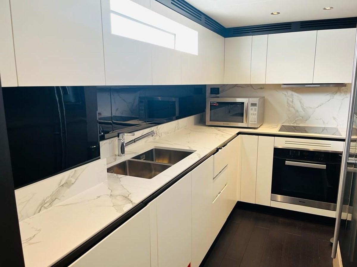 a kitchen with white cabinets aboard LULWA Yacht for Sale