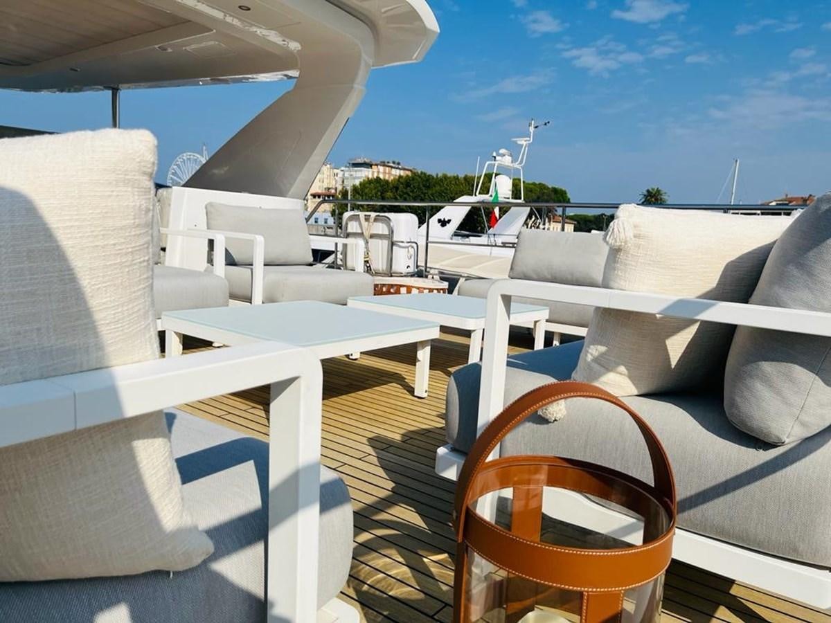 a deck with chairs and a body of water in the background aboard LULWA Yacht for Sale