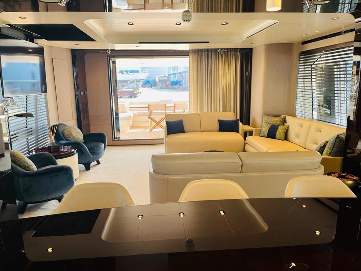 a room with a couch and a table with chairs and a window aboard LULWA Yacht for Sale