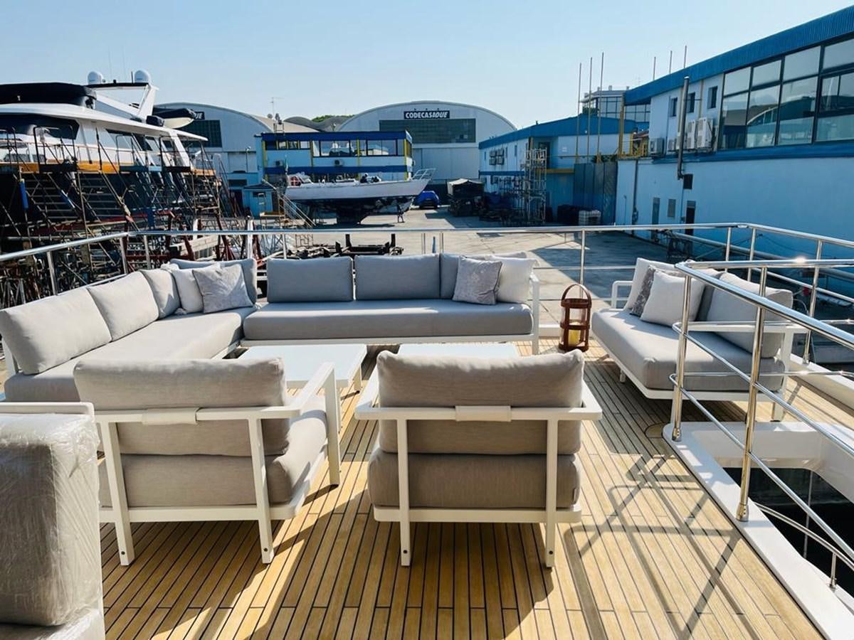 a deck with couches and a large body of water in the background aboard LULWA Yacht for Sale
