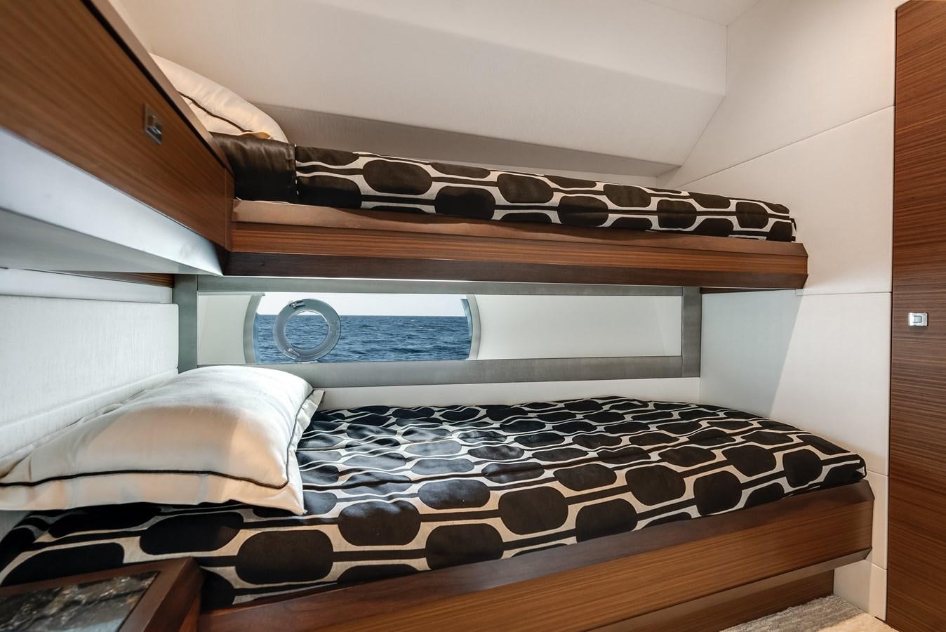 a shelf with a bed and a shelf with a book on it aboard 2018 OCEAN ALEXANDER 70E TIRESUM Yacht for Sale