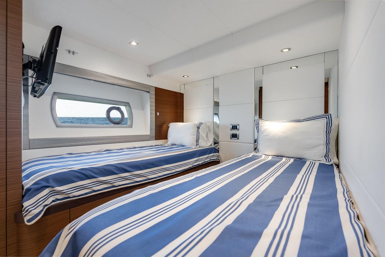 a bedroom with a blue and white striped bed and a white wall aboard 2018 OCEAN ALEXANDER 70E TIRESUM Yacht for Sale