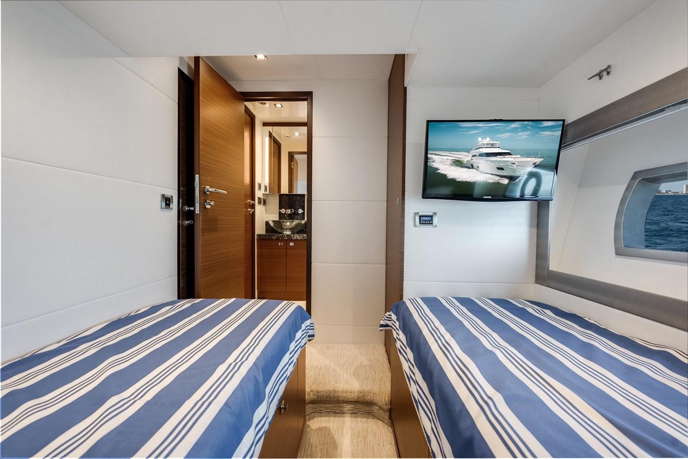 a bedroom with a tv on the wall aboard 2018 OCEAN ALEXANDER 70E TIRESUM Yacht for Sale