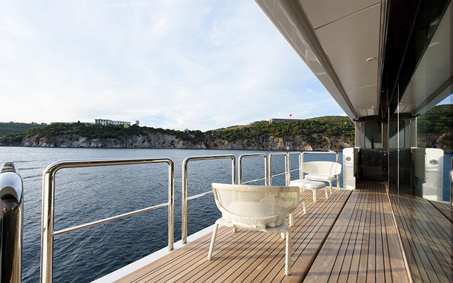 a deck with a view of the water and trees aboard MARUN Yacht for Sale
