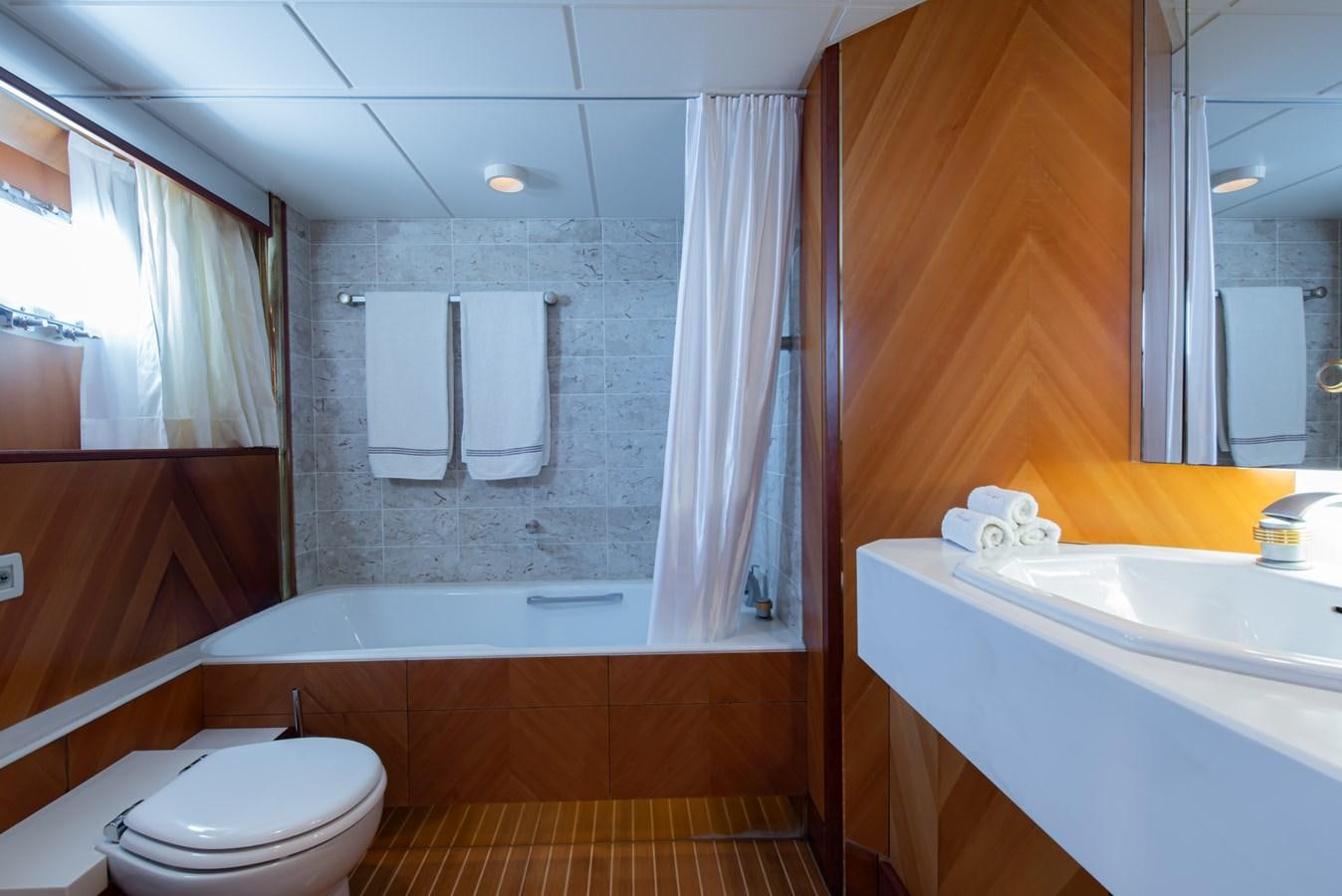 a bathroom with a tub sink and toilet aboard SHEERGOLD Yacht for Sale