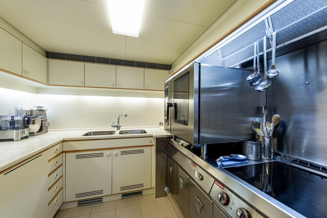 a kitchen with white cabinets aboard SHEERGOLD Yacht for Sale