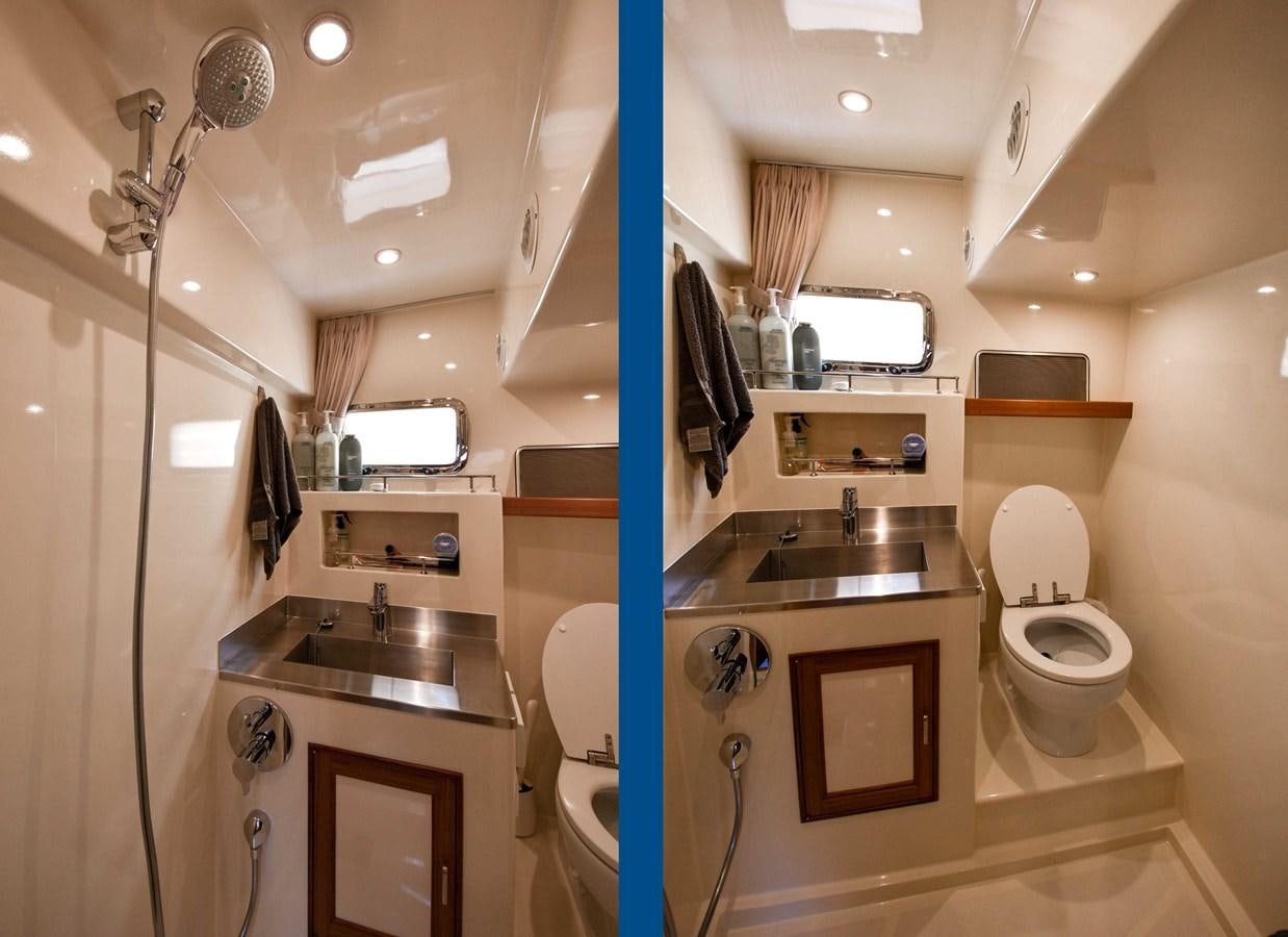 a bathroom with a toilet sink and a mirror aboard FLEMING 78 - CLASSIC FLYBRIDGE Yacht for Sale