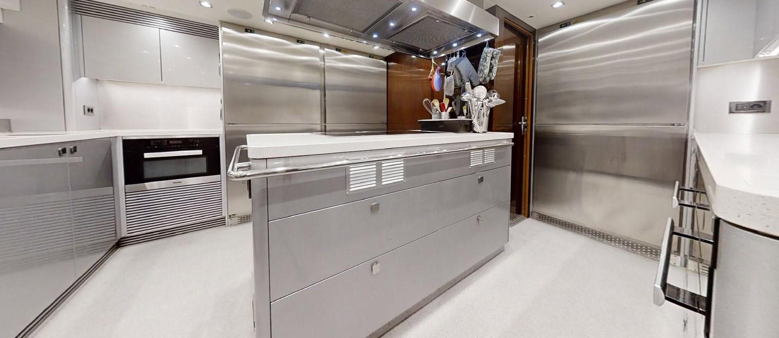 a large kitchen with white cabinets aboard ROGUE Yacht for Sale