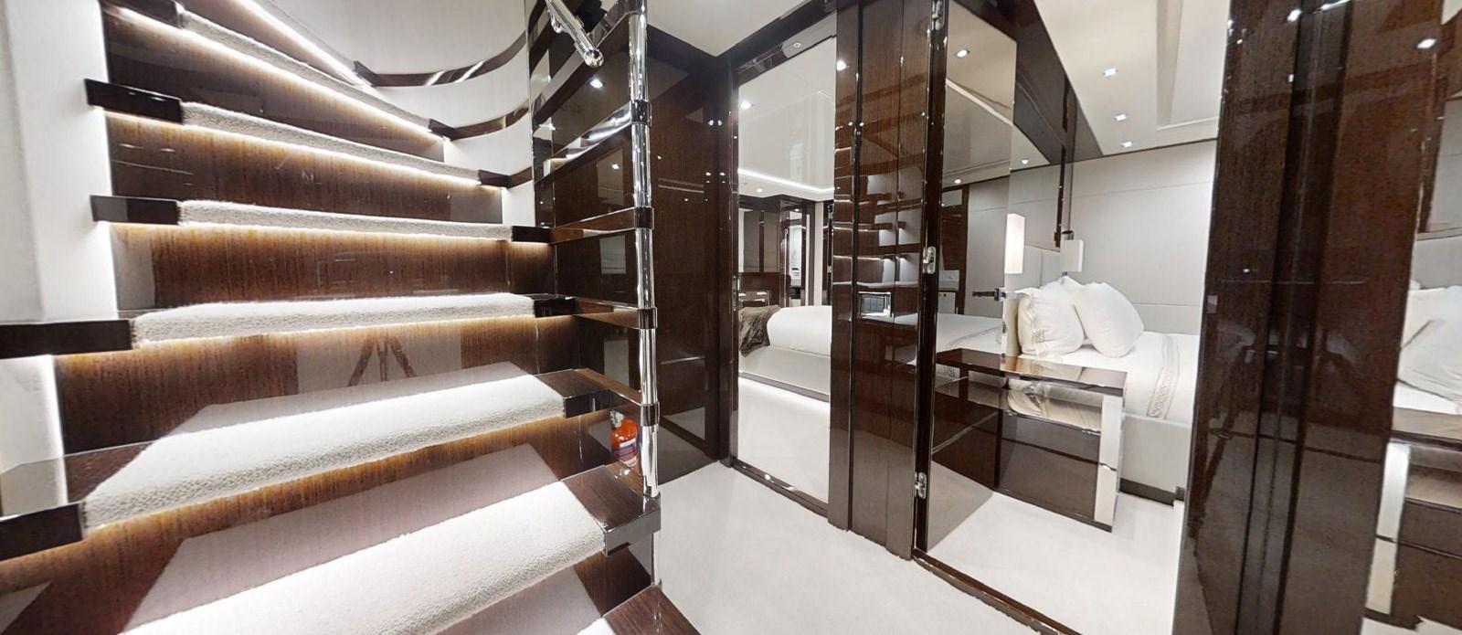a room with a bed and a wood staircase aboard ROGUE Yacht for Sale