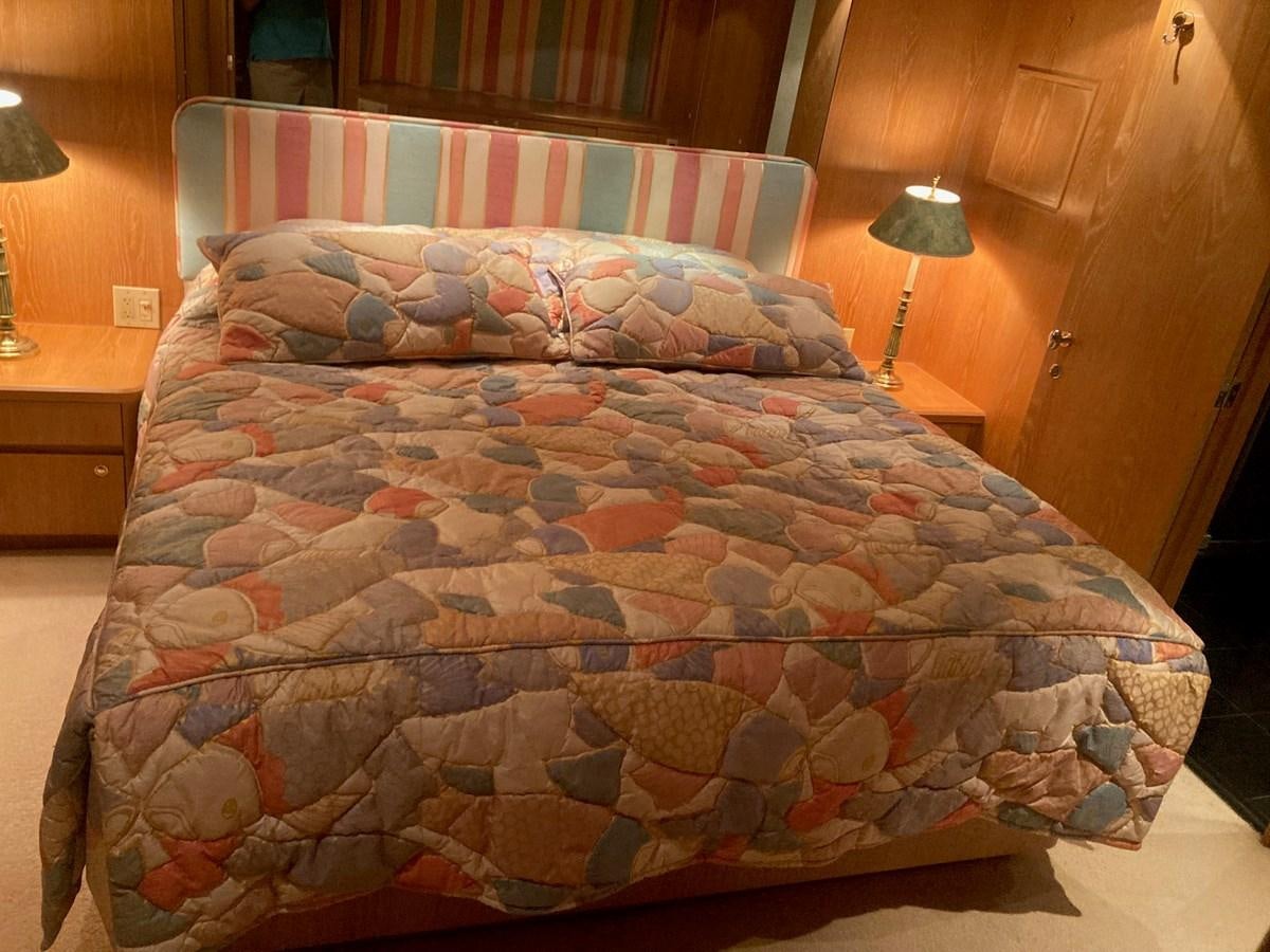 a bed with a colorful comforter aboard LADY JANE Yacht for Sale