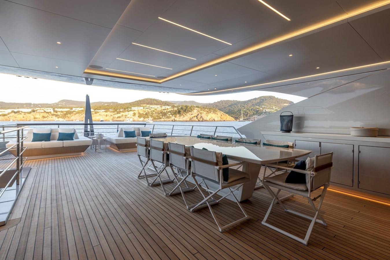a deck with tables and chairs aboard NO STRESS Yacht for Sale